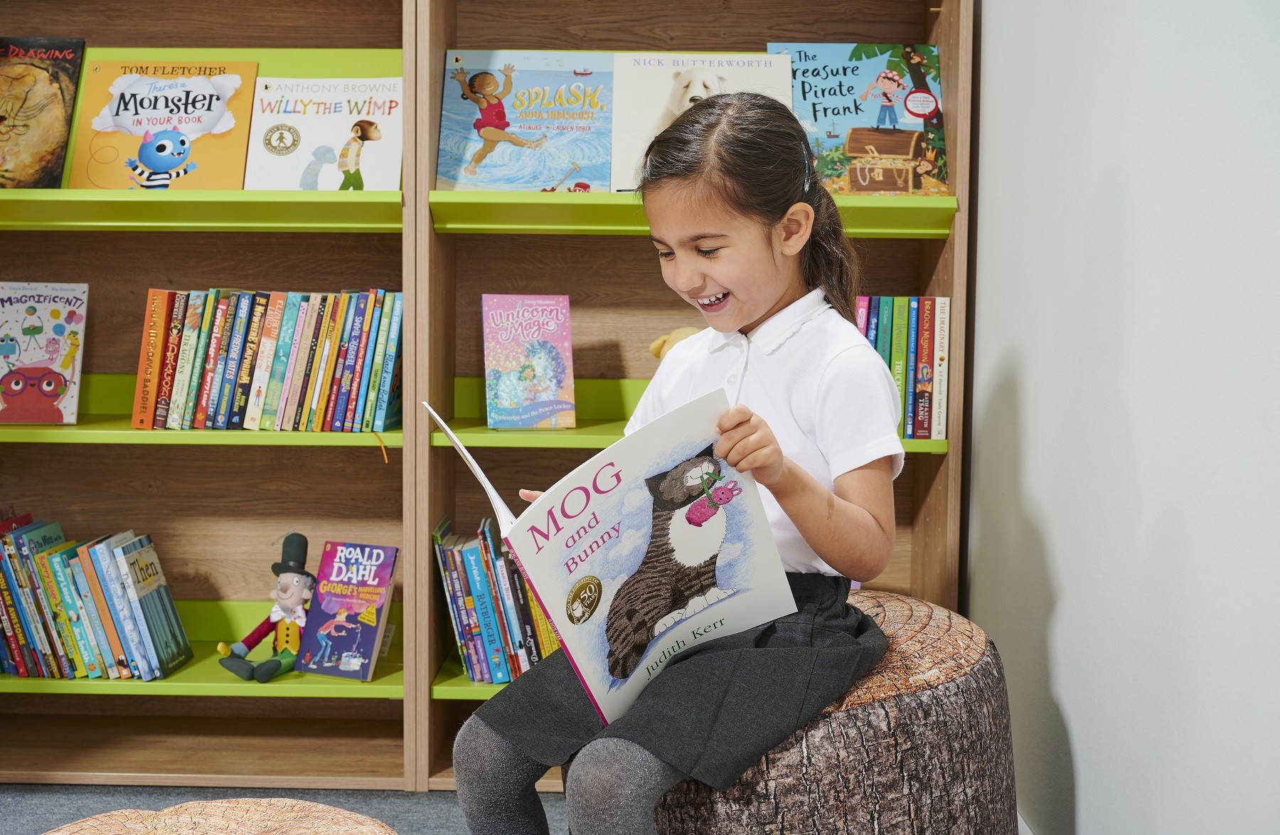 A pupil reading in her schools children's reading corner